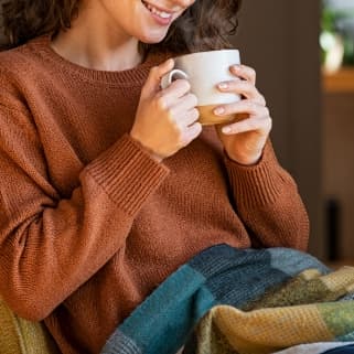 Eine Frau trinkt genüsslich eine Tasse Heimbs Kaffee