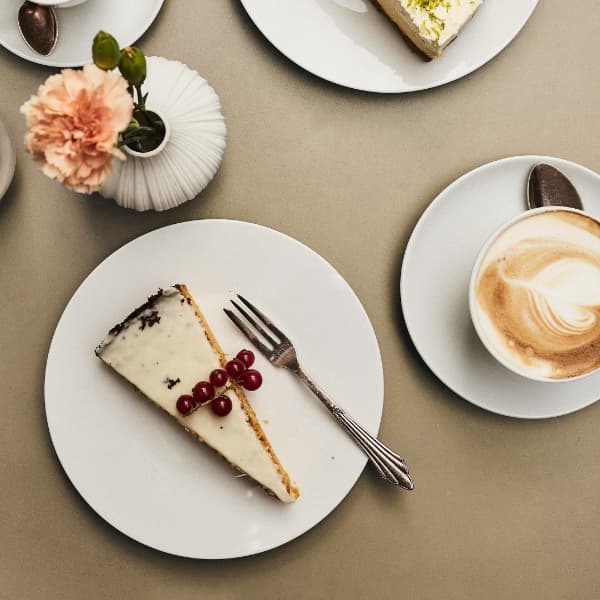 Kaffee und Kuchen mit einer Tasse Heimbs Cappuccino mit Latte Art Herz