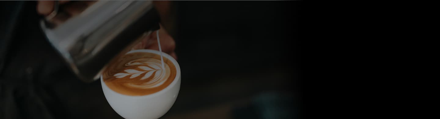 Barista gießt Latte Art in eine Dallmayr Cappuccino Tasse